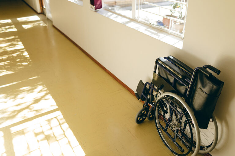 Wheelchair positioned in a retirement community hallway maintained with clean commercial painting and facility maintenance services